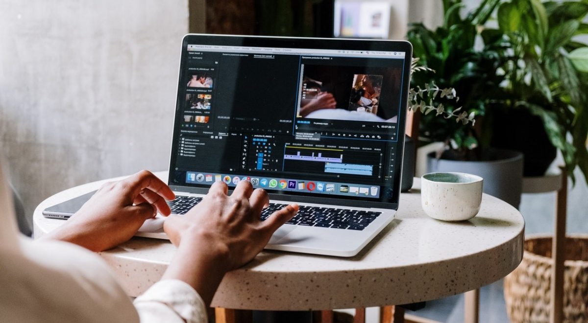 brown hands editing at laptop