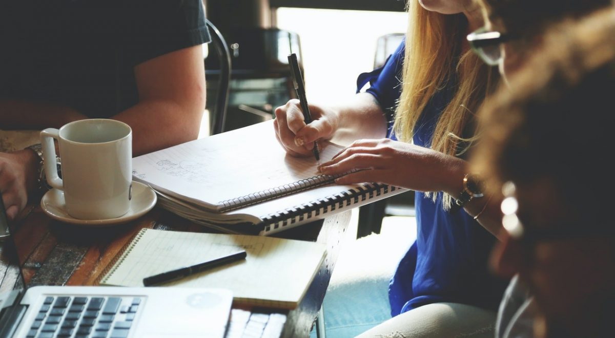 Group of people with notebooks and laptops planning