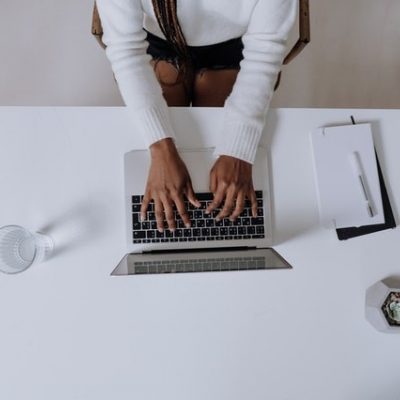 Aerial shot of a desk with hand typing