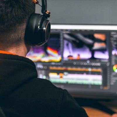 Person with headphones working on Adobe Software