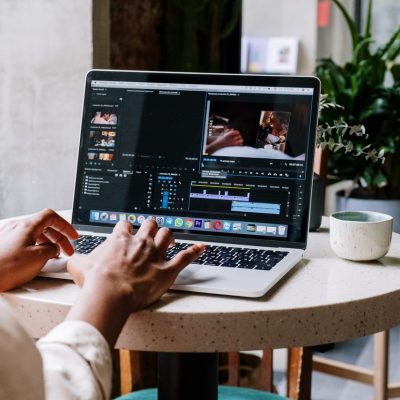 brown hands editing at laptop